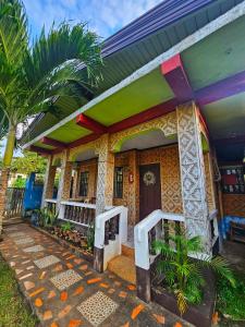a colorful house with a palm tree in front of it at Bohol Sea Breeze Cottages and Resort in Panglao