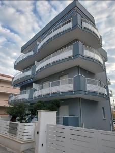 a blue building with a white fence in front of it at Grey House 4 100mt dal mare in Tortoreto Lido