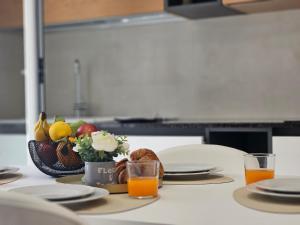 a table with a bowl of fruit and orange juice at Grey House 4 100mt dal mare in Tortoreto Lido