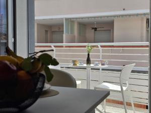 a balcony with a table and chairs and a vase of flowers at Grey House 4 100mt dal mare in Tortoreto Lido +24 photos