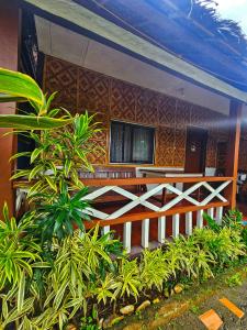 a house with a fence and a tv on the wall at Bohol Sea Breeze Cottages and Resort in Panglao