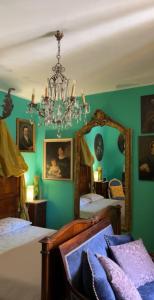 a green bedroom with two beds and a chandelier at Art action room 