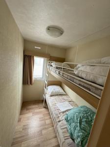 Cette chambre comprend deux lits superposés et un lit. dans l'établissement Camping L'Orée des Caps, à Licques