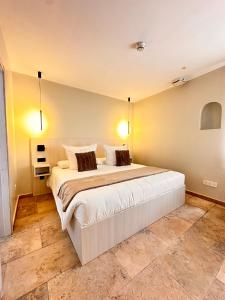 una camera da letto con un grande letto bianco con due cuscini di AlliOli Boutique Hotel Spa a Castelló d'Empúries