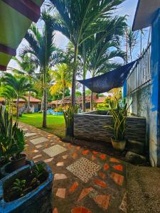 a garden with palm trees and a blue building at Bohol Sea Breeze Cottages and Resort in Panglao