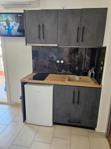 uma cozinha com um lavatório e uma bancada em petros house em Sarti