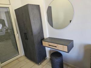 a bathroom with a vanity and a mirror and a stool at petros house in Sarti