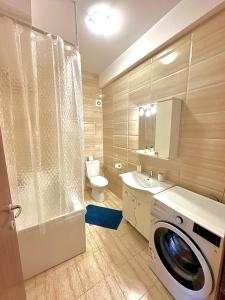 uma casa de banho com uma máquina de lavar roupa e um WC em Marcony Summerland Apartments em Mamaia