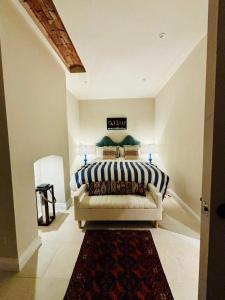 1 dormitorio con 1 cama con sofá y alfombra en The Old Rectory Tack Rooms, en Shrewsbury