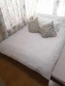 a white bed with two pillows on top of it at Tokyo downtown in Tokyo