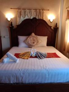 a bed with two ribbons on top of it at Sakura Wood House in Luang Prabang