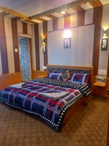 斯利那加的住宿－Srinagar hotels and houseboats，一间卧室配有一张大床和一张铺着条纹毯子