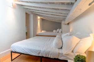 1 Schlafzimmer mit 2 Betten und weißer Bettwäsche in der Unterkunft Fossi tower in Florenz