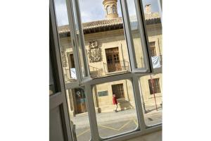 a window view of a building with a person walking down the street at Los Sueños de Ixana in Haro