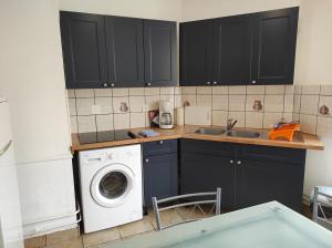 eine Küche mit einer Waschmaschine und einem Waschbecken in der Unterkunft Superbe F3 dans résidence calme, in Nancy