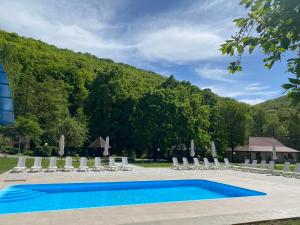 una piscina con tumbonas y una montaña en Bogolvar Retreat Resort, en Antalovtsi