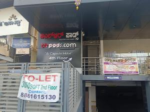 ein Geschäft mit Schildern an der Seite eines Gebäudes in der Unterkunft BLR Pods in Bangalore
