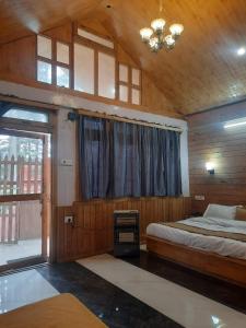 a bedroom with a large bed and a window at cedar tree cottage gadakufri in Matiāna