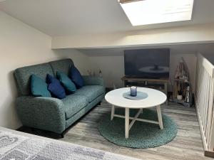 een woonkamer met een bank en een tafel bij Hameaux de la plage in Gruissan