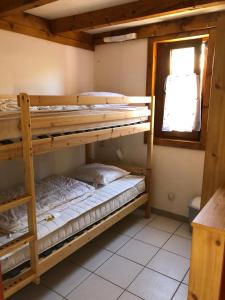twee stapelbedden in een kamer met een raam bij Hameaux de la plage in Gruissan