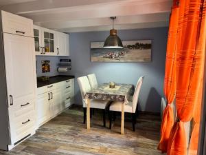 een eetkamer met een tafel en twee stoelen bij Hameaux de la plage in Gruissan