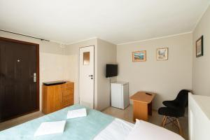 1 dormitorio con cama, escritorio y puerta en Willa Tina, en Karwia