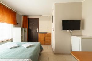 a bedroom with a bed and a flat screen tv at Willa Tina in Karwia
