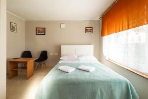a bedroom with a bed and a desk and a window at Willa Tina in Karwia