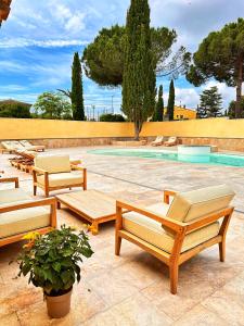 una fila de bancos de madera junto a una piscina en AlliOli Boutique Hotel Spa en Castellón de Ampurias