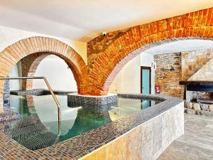 een binnenzwembad met een bakstenen muur bij AlliOli Boutique Hotel Spa in Castelló d'Empúries