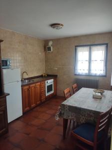 Il comprend une cuisine équipée d'une table et d'un réfrigérateur blanc. dans l'établissement Casa Rural Juaco, à Bimenes