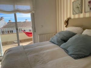 a bed in a bedroom with a large window at Preciosa casa de playa in S'Agaro +38 photos