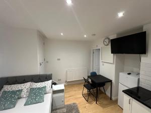 a bedroom with a bed and a table and a desk at 1st Studio Flat With full Private Toilet And Shower With its Own Kitchenette in Keedonwood Road Bromley A Fully Equipped Independent Studio Flat in Bromley