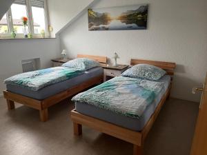 two twin beds in a room with two windows at Ferienwohnung Sonnenschein in Grenzach-Wyhlen