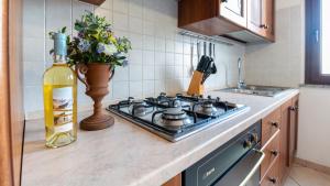 um balcão de cozinha com um fogão e uma garrafa de vinho em Casa Via Leopardi 124 em Càbras