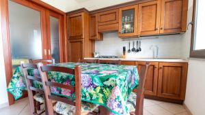 uma cozinha com uma mesa e cadeiras e um lavatório em Casa Via Leopardi 124 em Càbras mais 38 fotografias