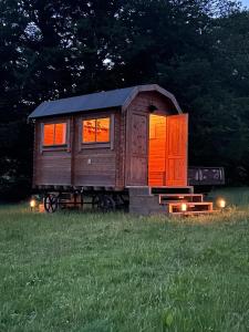 Una casita en un campo con luces encendidas. en Gwynfyd Bell Tent, en Abergavenny