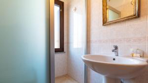 um banheiro com pia e espelho em Casa Via Leopardi 124 em Càbras