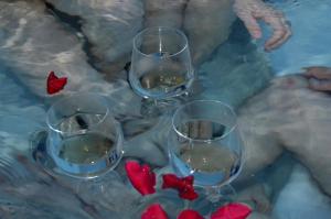 tres copas de vino sentadas en una mesa con corazones rojos en Boka View by Roši en Tivat