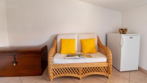 uma cadeira de vime com duas almofadas amarelas e livros em Casa Via Leopardi 124 em Càbras