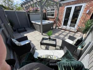 an outdoor patio with chairs and a hot tub at Beachside Suites - HOT TUB sleeps 10 in Blackpool