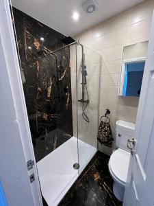 a bathroom with a glass shower with a toilet at Beachside Suites - HOT TUB sleeps 10 in Blackpool +22 photos