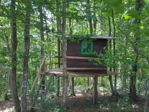 a tree house in the woods with a ladder at Bakina iža in Duga Resa