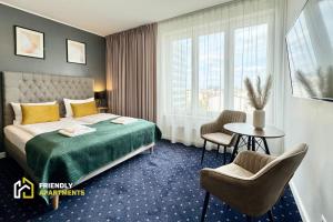 a hotel room with a bed and a table and chairs at SERENITY Residence - Old Town Poznan by Friendly Apartments in Poznań