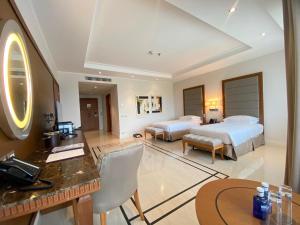 um quarto de hotel com duas camas e uma secretária em Grand Hotel Djibloho em Djibloho