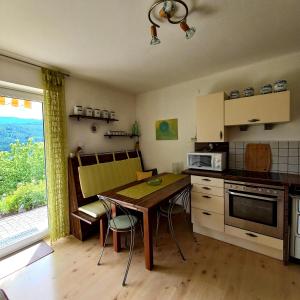 una cucina con tavolo e sedie e una cucina con finestra di Ferienwohnung Energie Oase a Millstatt