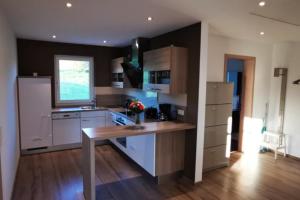 a kitchen with white cabinets and a table in it at Ferienwohnung BergPanorama Rhön in Gersfeld