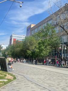 un grupo de personas caminando por una calle de la ciudad en Квартира en Almaty