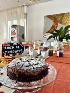 una torta al cioccolato su un piatto su un tavolo di Hotel B&B Ardea Rimini a Rimini
