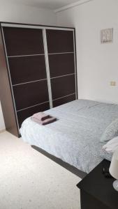 a bedroom with a large bed with a large headboard at Apartamento Sol A air conditioning in Vecindario